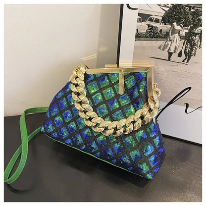 Patterned handbag with gold chain detail on a dark surface