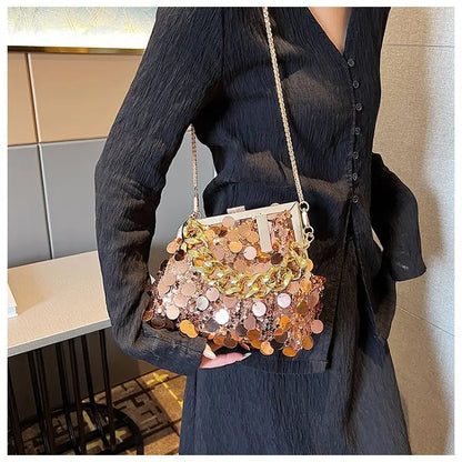Person holding a glittery handbag with a sequined design in an indoor setting.