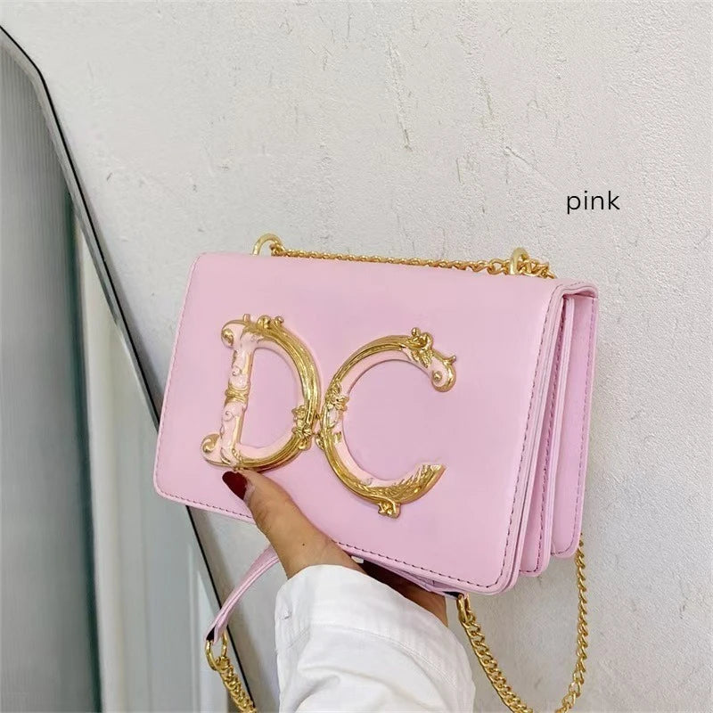 Pink Dolce_CaRaUaNa handbag with gold chain and 'DC' logo held by a hand