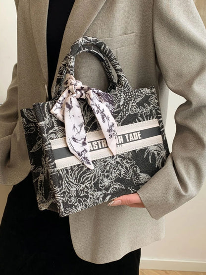 Person holding a patterned handbag with visible branding