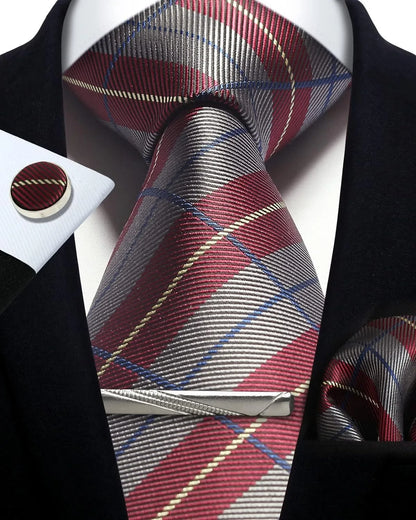 Plaid tie with matching pocket square and cufflinks on a suit jacket.