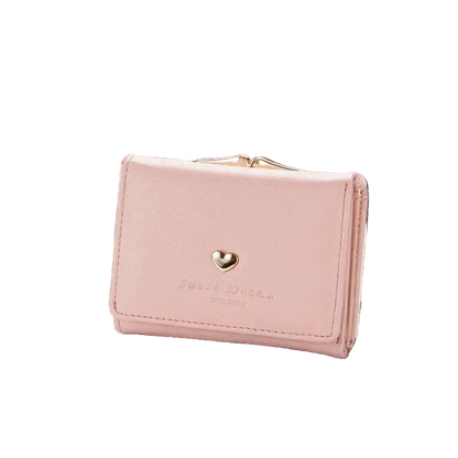 Pink wallet with a heart emblem on a magazine with sunglasses and bicycle in the background